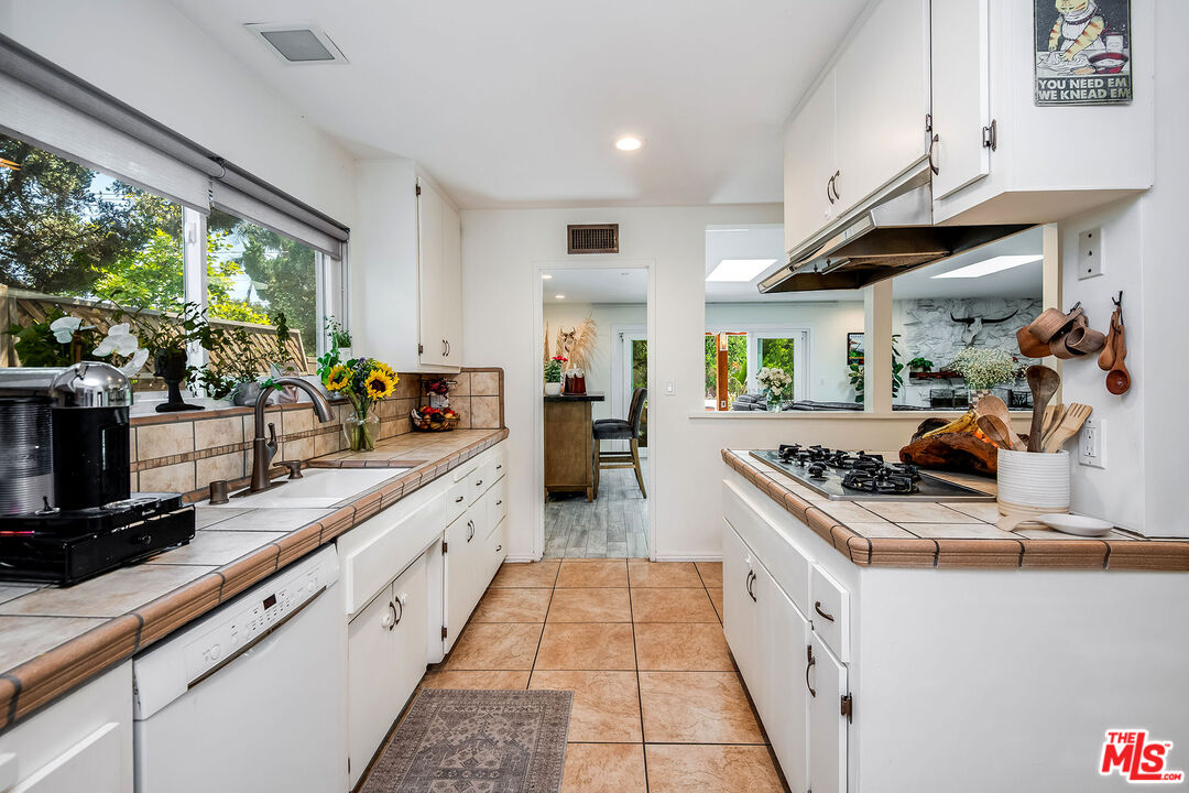 18924 Cantara Street Reseda, CA 91335 - Photo 8 of 31 a large white kitchen with stainless steel appliances granite countertop a stove and a sink