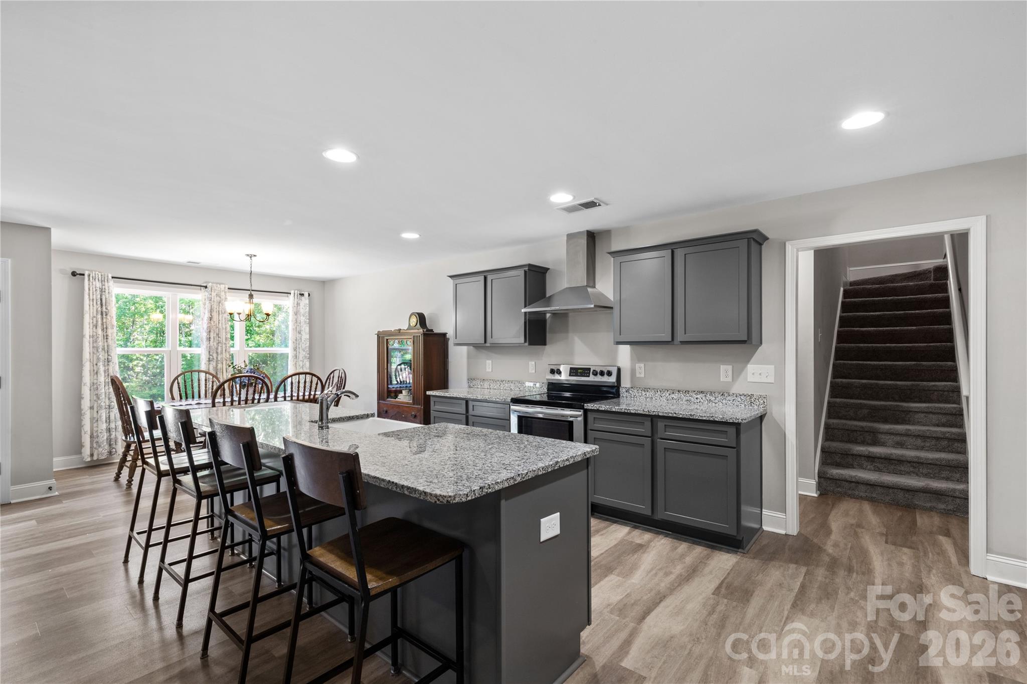 4335 Palmer Lloyd Road Lancaster, SC 29720 - Photo 13 of 33 a kitchen with stainless steel appliances granite countertop a kitchen island hardwood floor sink stove dining table and chairs