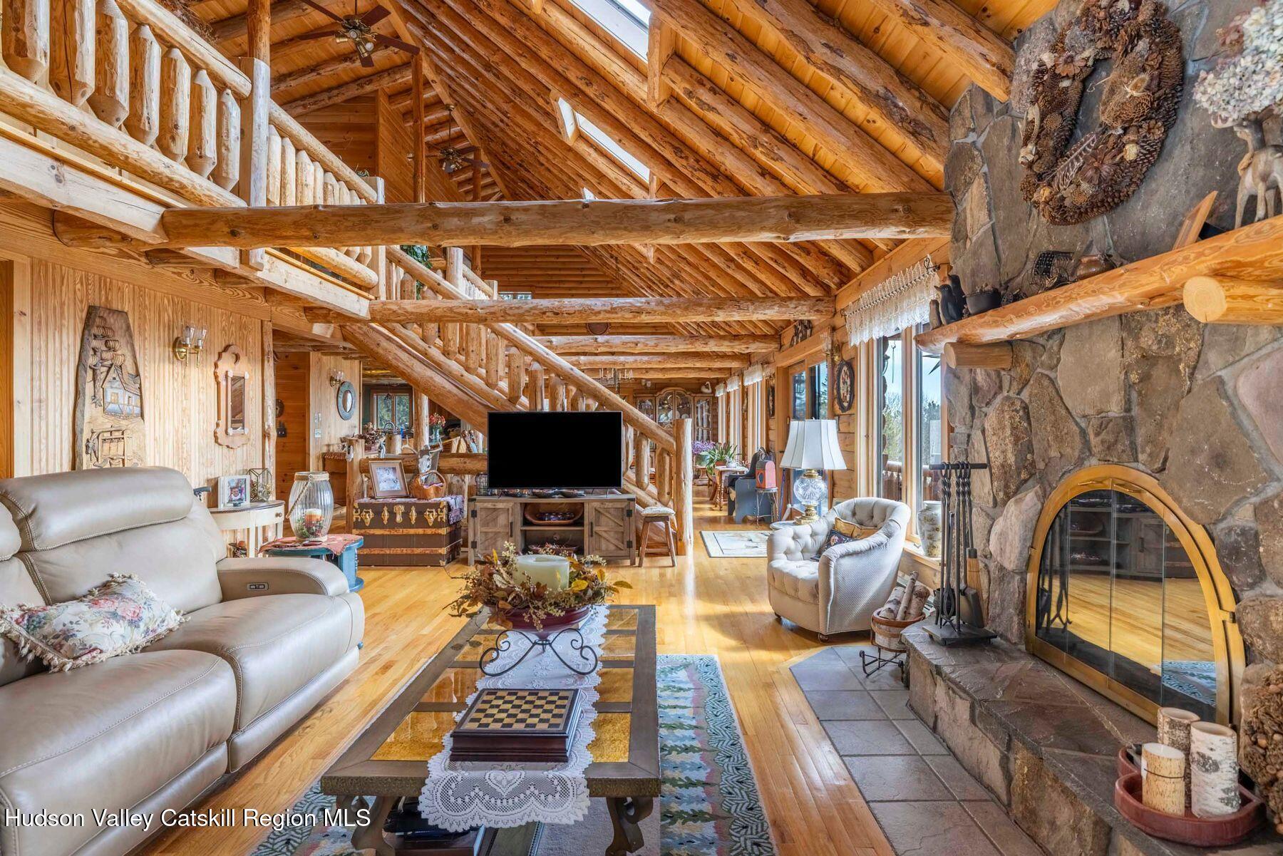 406 Cheese Hill Road Preston Hollow, NY 12469 - Photo 22 of 59 a living room with furniture a flat screen tv and a floor to ceiling window