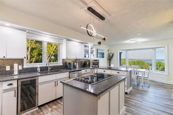 a kitchen with a stove a sink a kitchen island with a dining table and chairs