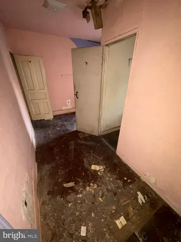 a view of an empty room with two window and a living room