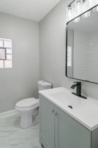 a bathroom with a sink toilet and mirror