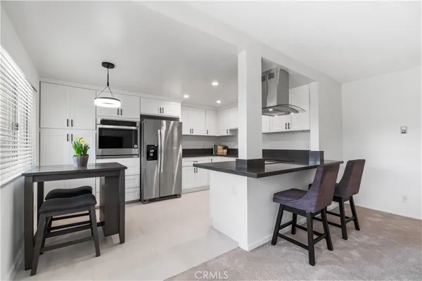 a kitchen with refrigerator cabinets dining table and chairs