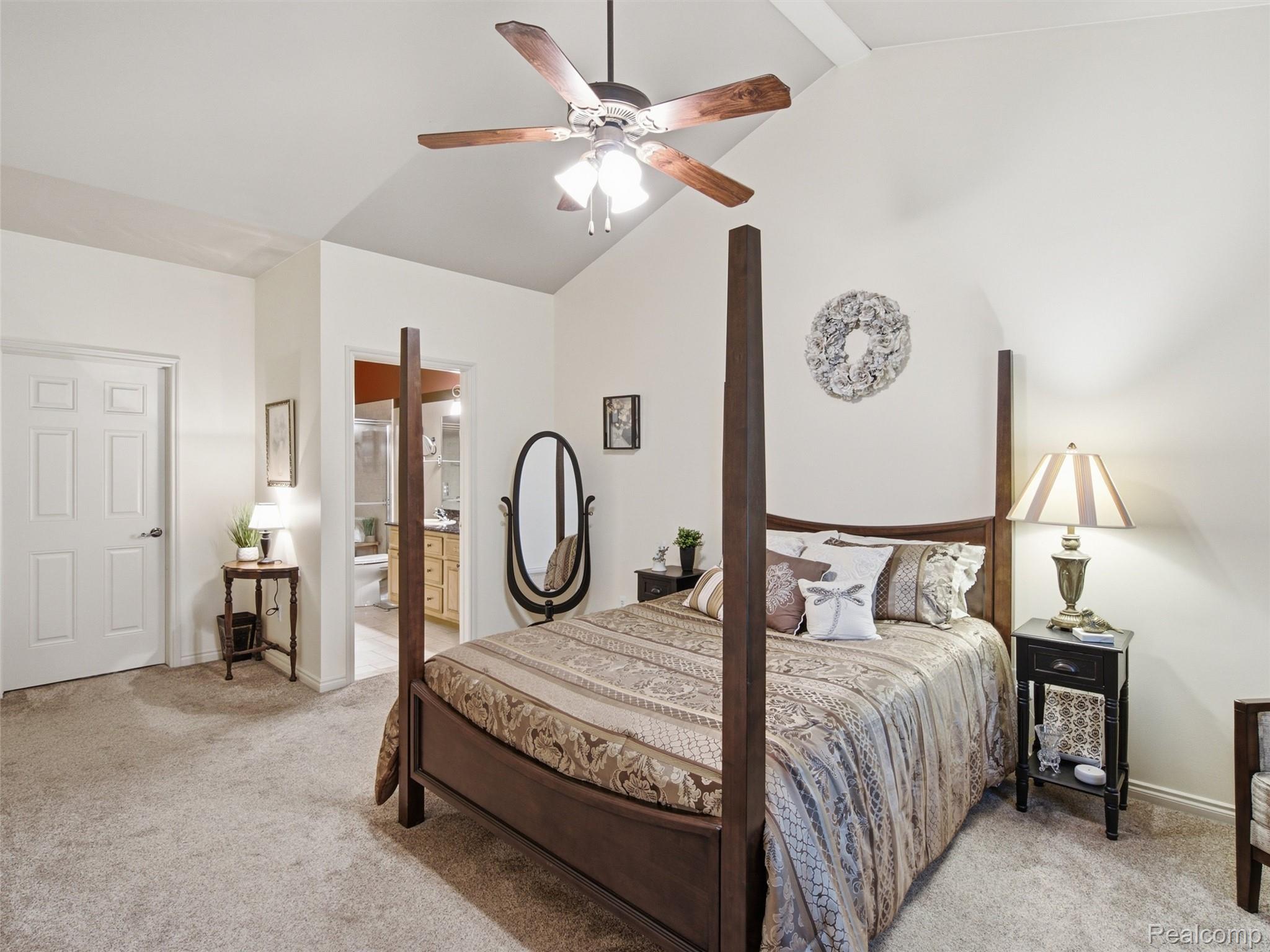 2633 Ridgecrest Drive Utica, MI 48316 - Photo 11 of 28 Primary bedroom featuring luscious carpeting, a vaulted ceiling with a ceiling fan, a window with blinds, and neutral wall tones. View of walk in closet and Primary Bathroom.