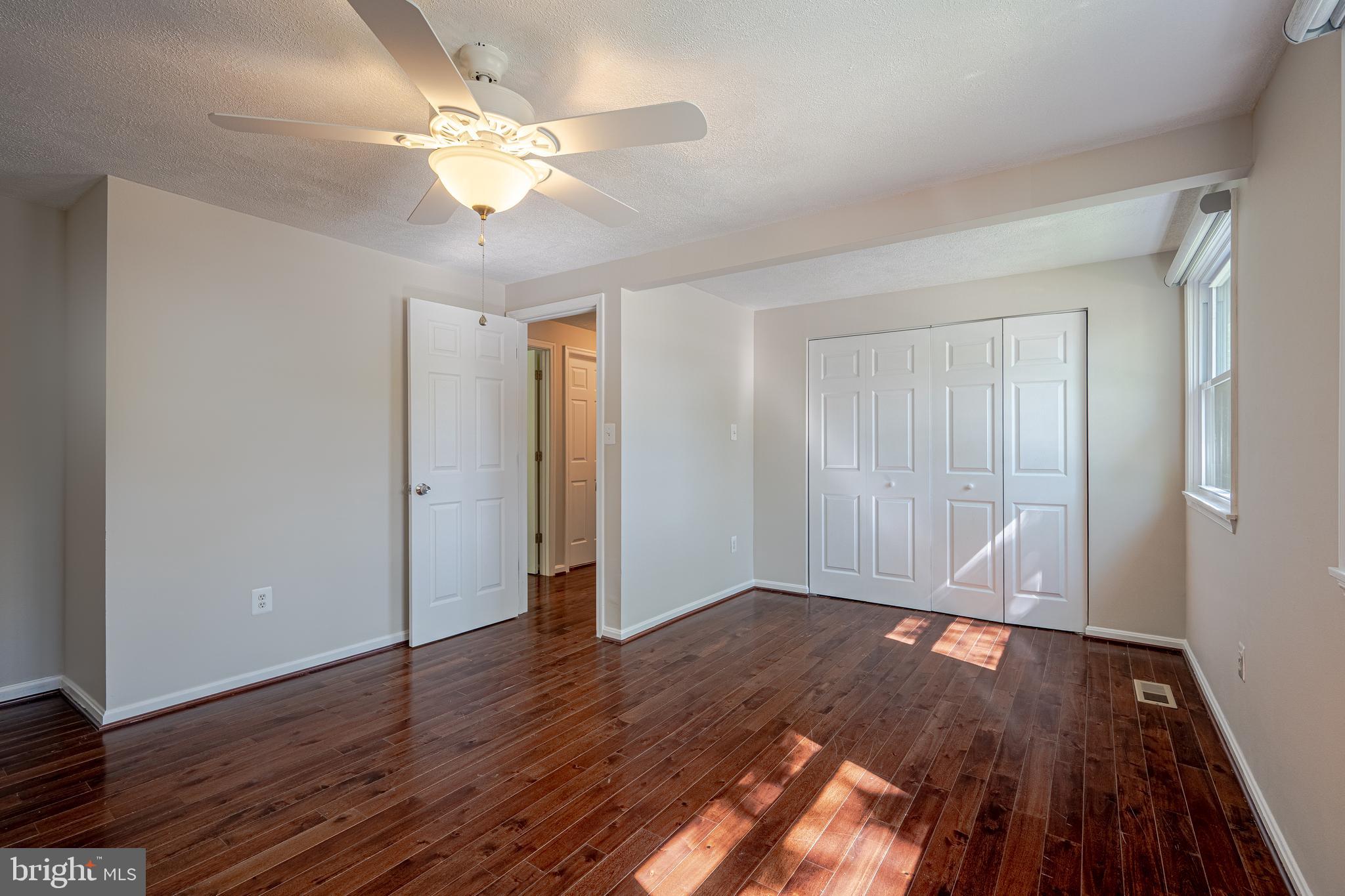 1784 Valleyside Drive Frederick, MD 21702 - Photo 12 of 42 an empty room with wooden floor and a ceiling fan