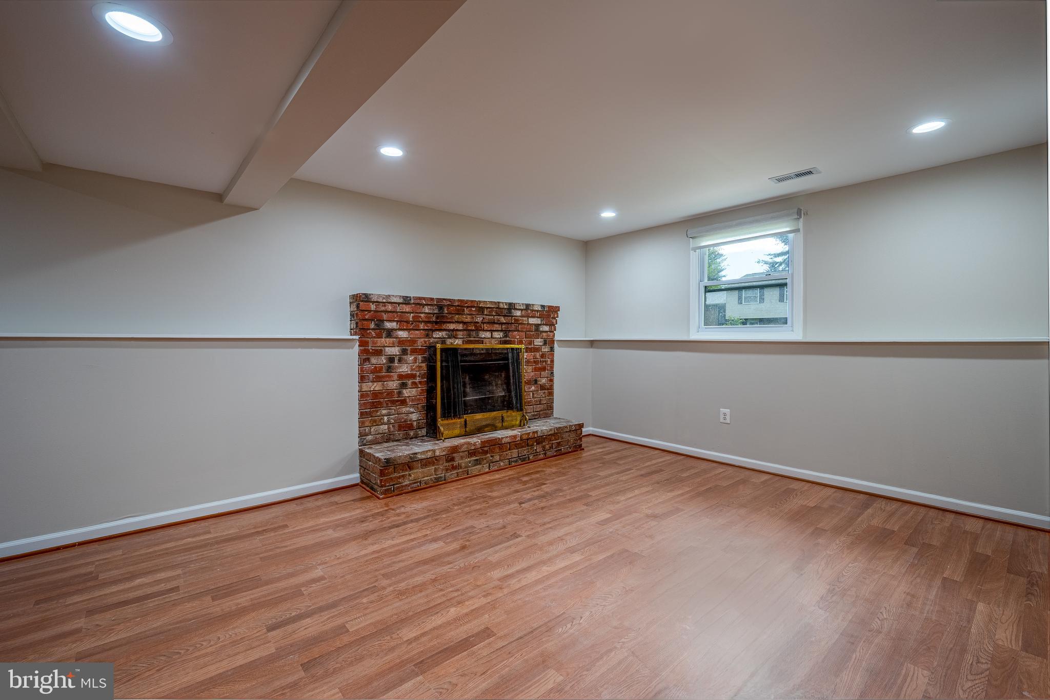 1784 Valleyside Drive Frederick, MD 21702 - Photo 19 of 42 an empty room with wooden floor and fireplace