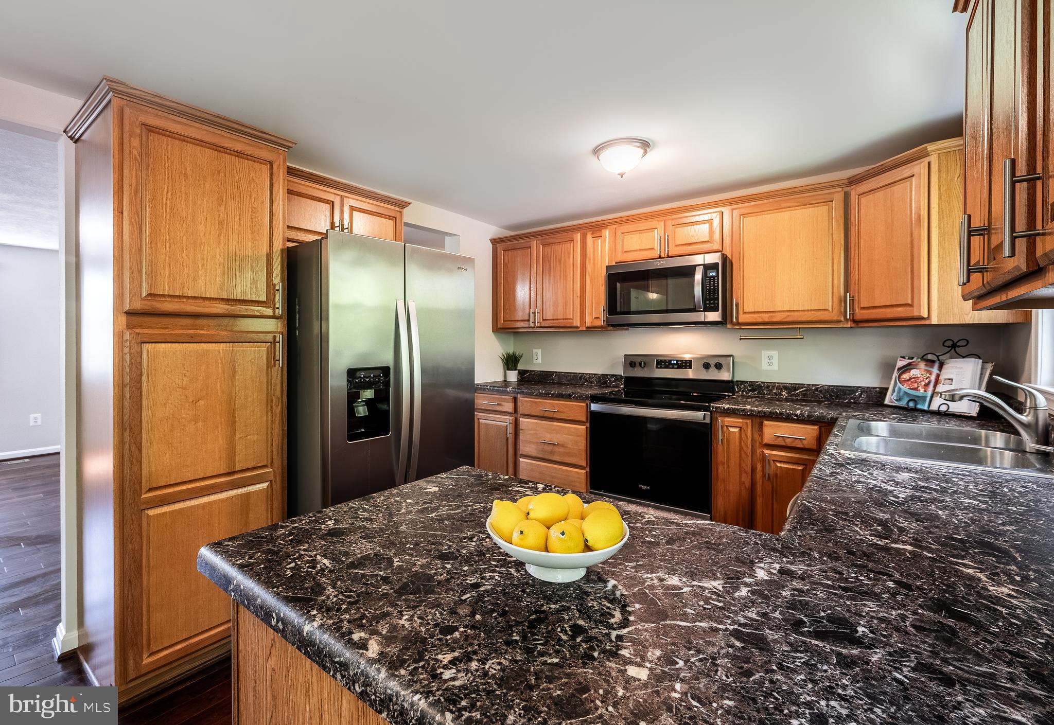 1784 Valleyside Drive Frederick, MD 21702 - Photo 7 of 42 a kitchen with granite countertop a refrigerator stove and oven