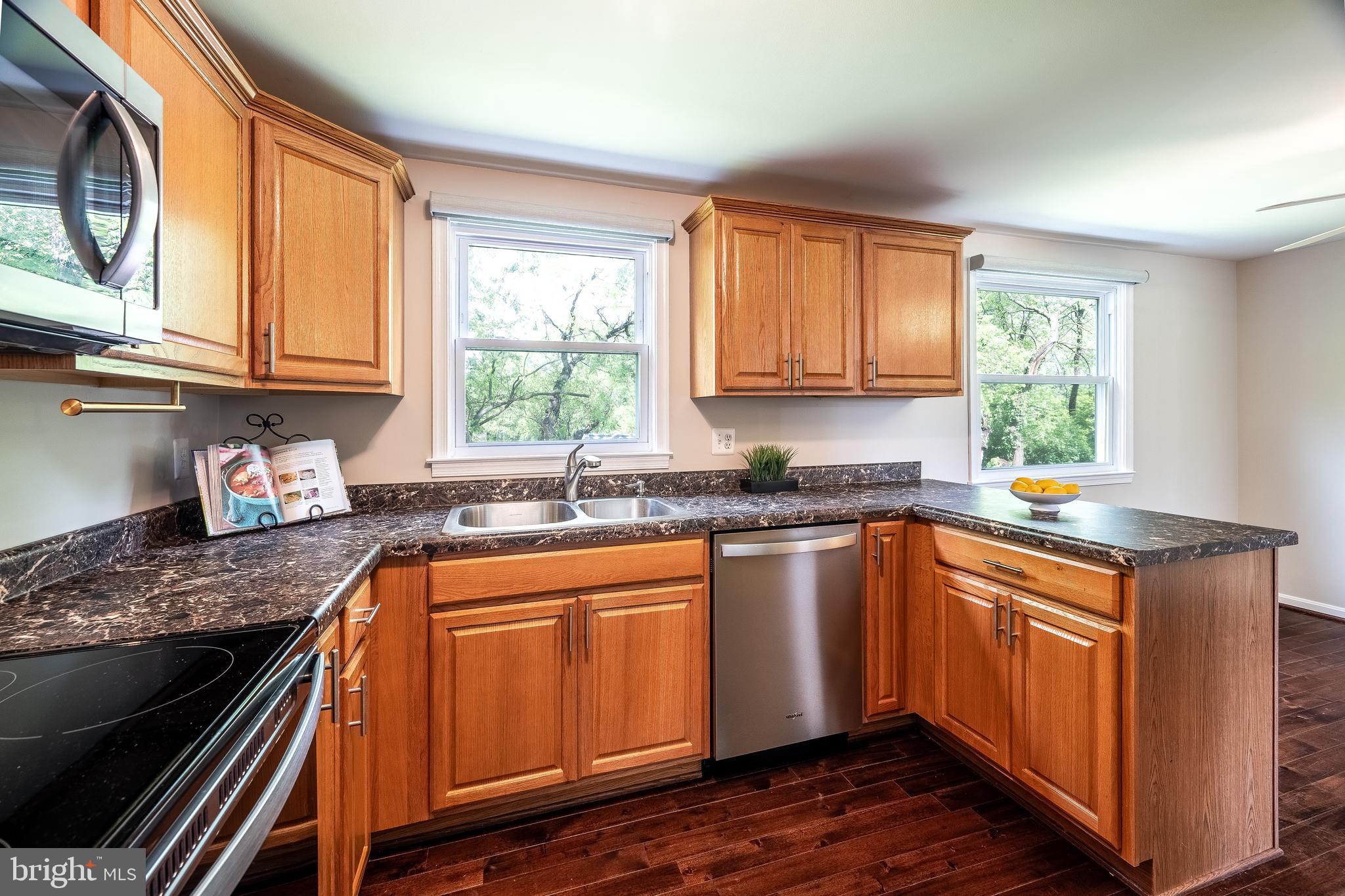 1784 Valleyside Drive Frederick, MD 21702 - Photo 9 of 42 a kitchen with granite countertop wooden cabinets a sink and a window