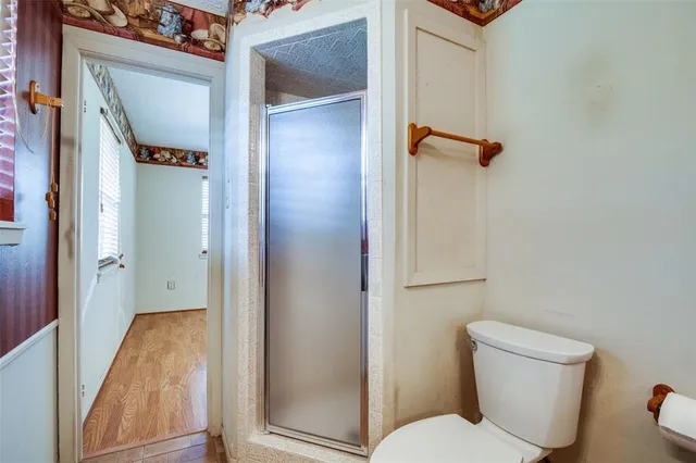 a bathroom with a toilet and a shower