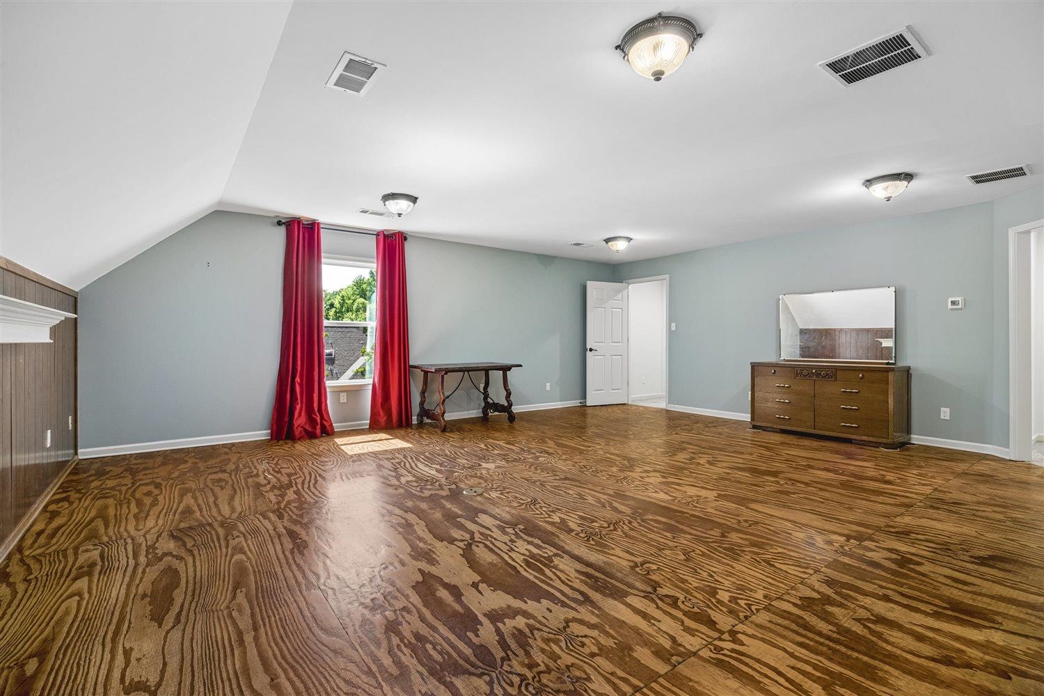 8970 Farmoor Road Germantown, TN 38139 - Photo 24 of 35 Spacious room featuring wood-finish flooring, light blue wall paint, and a sloped ceiling