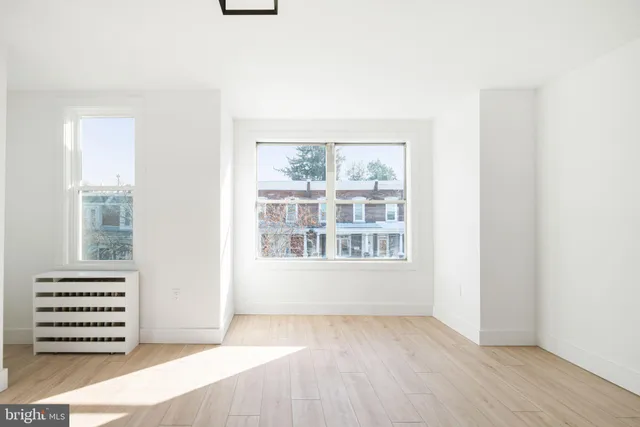 an empty room with a window and a mirror