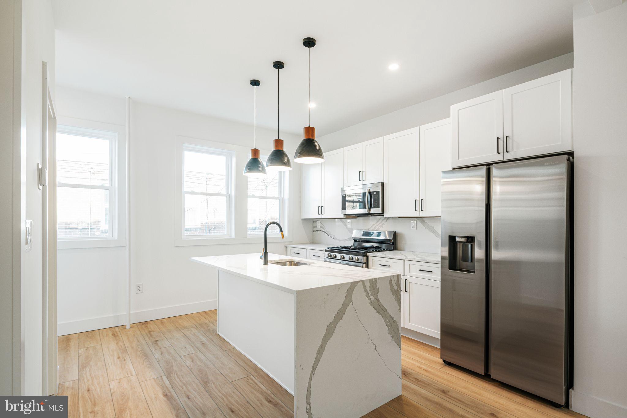 448 Markle Street Philadelphia, PA 19128 - Photo 7 of 21 a kitchen with stainless steel appliances granite countertop a refrigerator a sink a stove a microwave and island with wooden floor