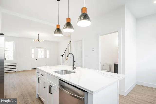 a kitchen with a sink a stove and wooden floor