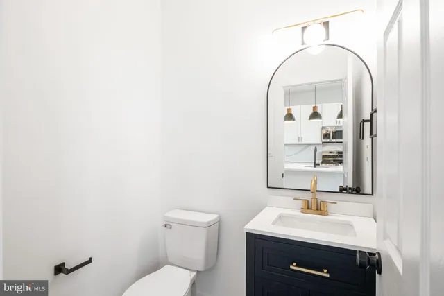 a bathroom with a toilet a sink and mirror