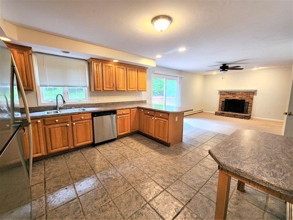 74 Lackey Dam Road Sutton, MA 01590 - Photo 7 of 17 a large kitchen with stainless steel appliances granite countertop a sink and cabinets