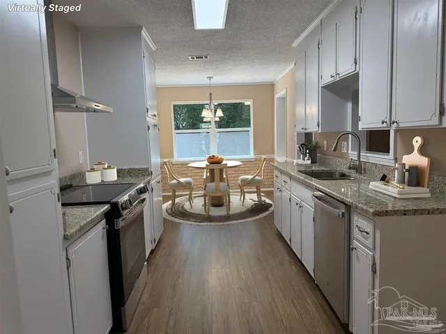 a kitchen with sink a stove and chairs