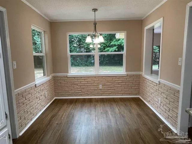 a view of a room with wooden floor and a window