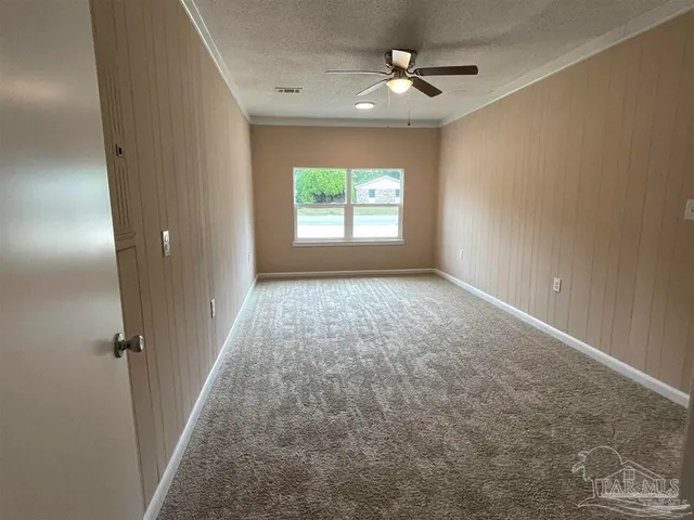an empty room with windows and fan