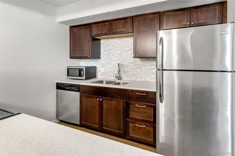 a kitchen with stainless steel appliances granite countertop a refrigerator and a sink