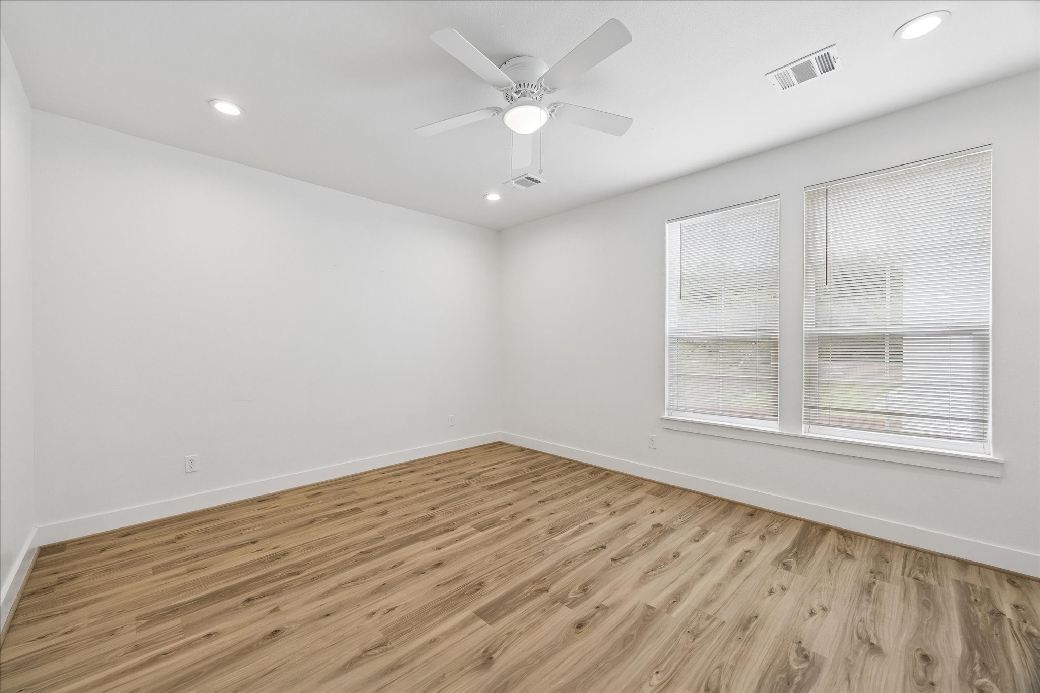 2749 Redrock Street, Unit B Houston, TX 77088 - Photo 13 of 24 Situated on the second level of the home is the primary suite with recessed lighting, a ceiling fan, windows with blinds, and luxury vinyl plank hardwood floors.