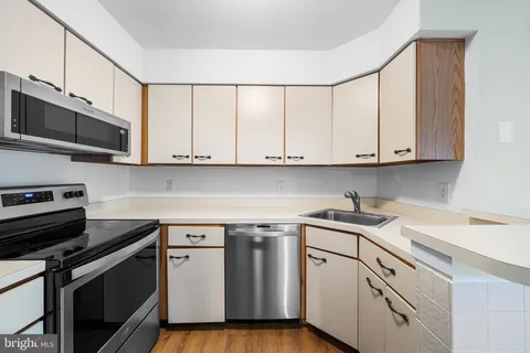 a kitchen with stainless steel appliances granite countertop a sink a stove a microwave and cabinets