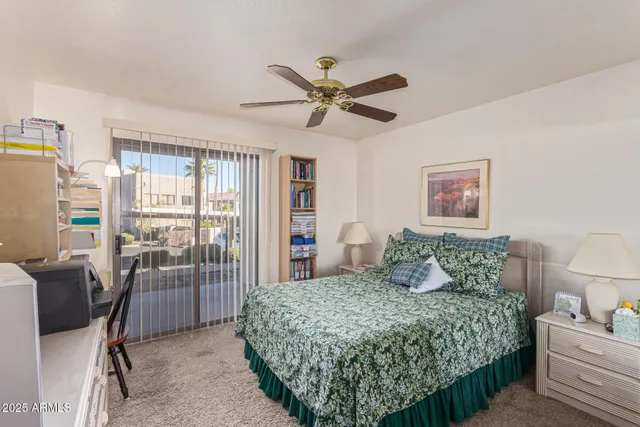 a bedroom with a bed a table and a chandelier