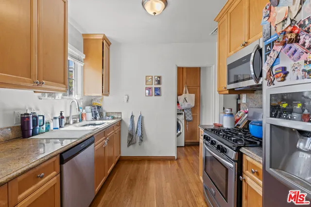 a kitchen with stainless steel appliances granite countertop a stove a sink and a refrigerator