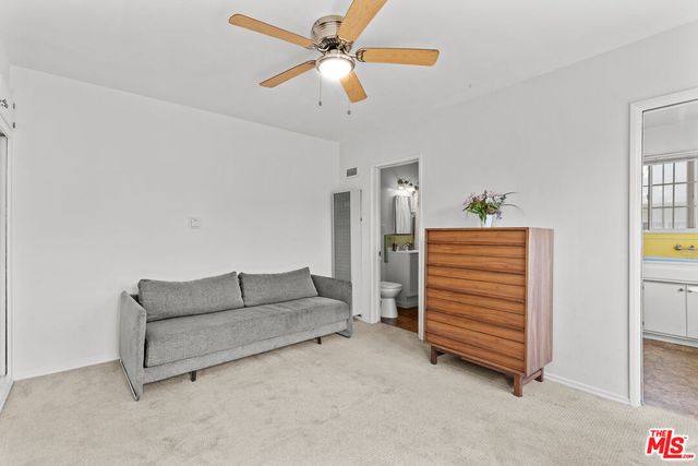 a living room with furniture and a ceiling fan