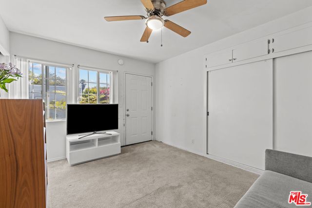 a view of an empty room with a window and a flat screen tv