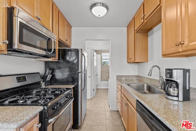 a kitchen with stainless steel appliances granite countertop a stove a sink and a microwave