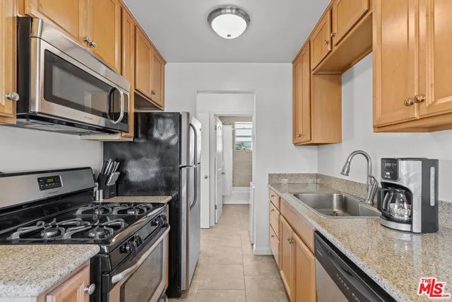 a kitchen with stainless steel appliances granite countertop a stove a sink and a microwave