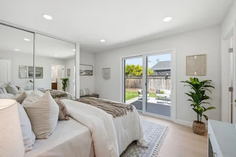 a spacious bedroom with a large bed and a potted plant