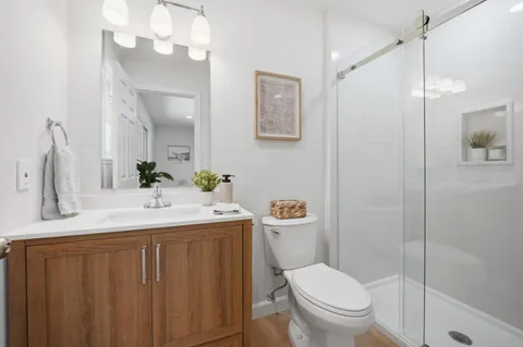 a bathroom with a sink vanity mirror and toilet