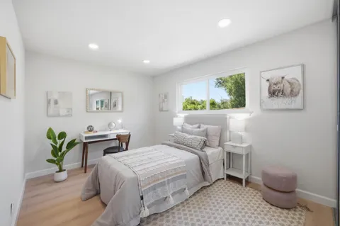 a bedroom with a bed a painting and wall painting