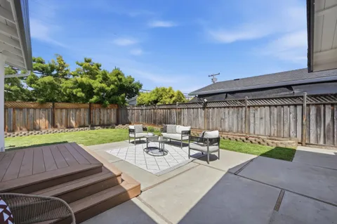 a backyard of a house with table and chairs