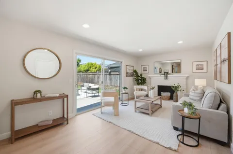 a living room with furniture a mirror and a large window
