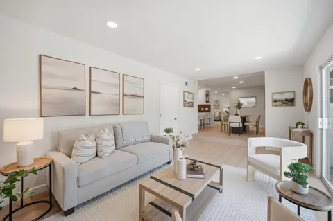 a living room with furniture kitchen view and a table