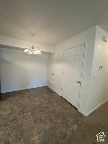 8196 North Cedar Springs Road, Unit 2 Eagle Mountain, UT 84005 - Photo 10 of 22 Unfurnished dining area with a textured ceiling and a chandelier
