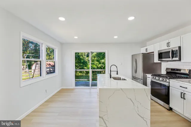 a kitchen with stainless steel appliances granite countertop a stove and a sink