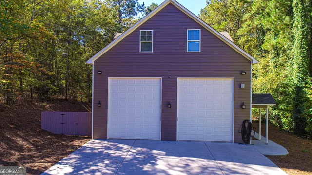 a living room with furniture a flat screen tv and kitchen view