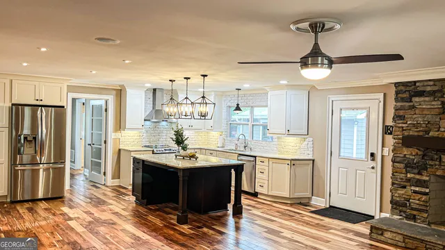a kitchen with stainless steel appliances granite countertop a refrigerator and a sink