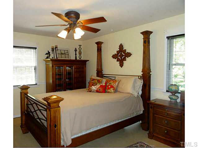 1008 Northclift Drive Raleigh, NC 27609 - Photo 8 of 21 a bedroom with a bed and a chandelier