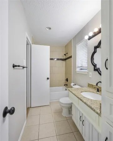 a bathroom with a granite countertop sink a mirror and a bathtub