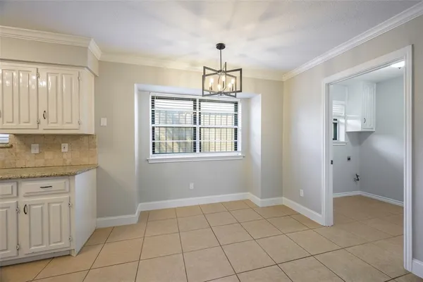 a view of an empty room with window and cabinet
