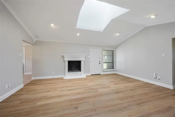 a view of empty room with wooden floor and fireplace