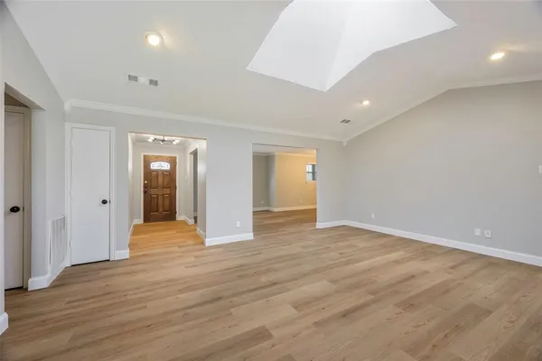 a view of an empty room with wooden floor and closet