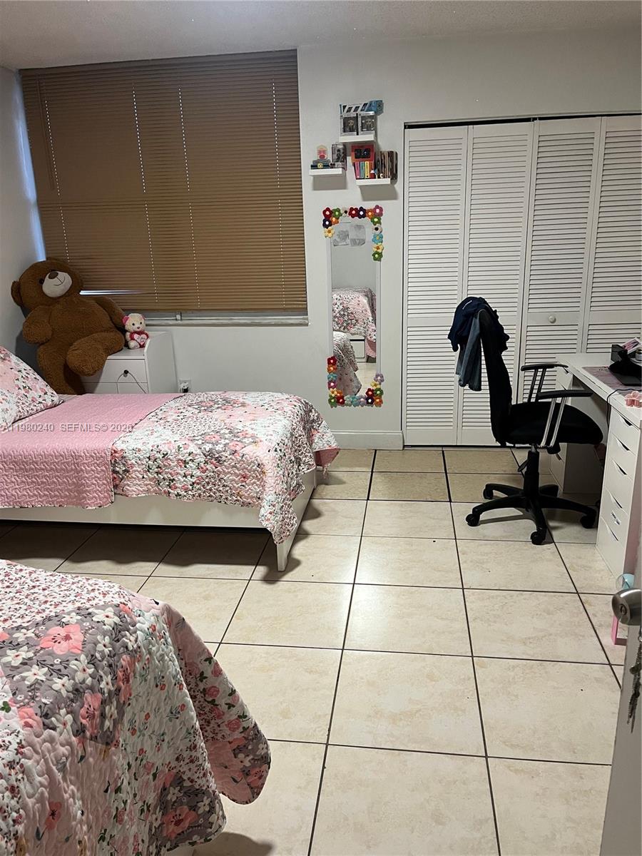 4331 West 11th Lane, Unit 65 Hialeah, FL 33012 - Photo 20 of 21 a bedroom with a bed and a stool