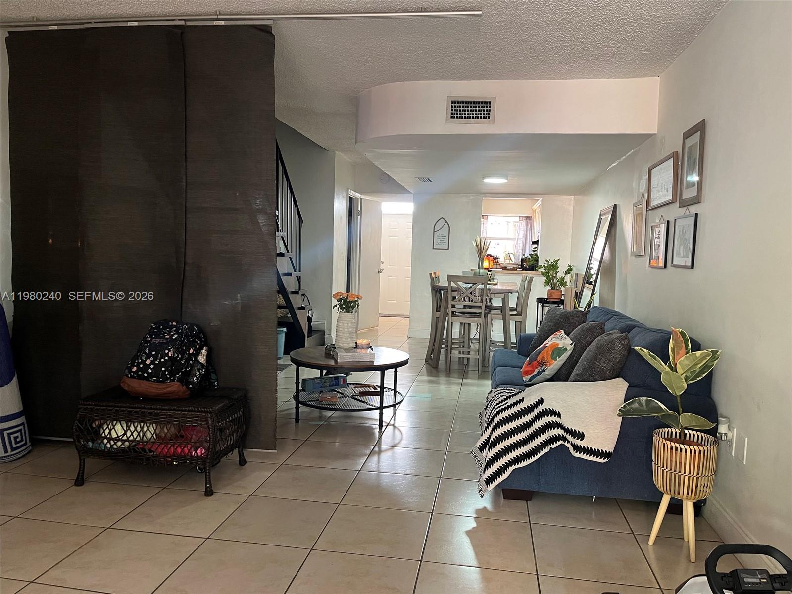 4331 West 11th Lane, Unit 65 Hialeah, FL 33012 - Photo 8 of 21 a living room with furniture and a chandelier