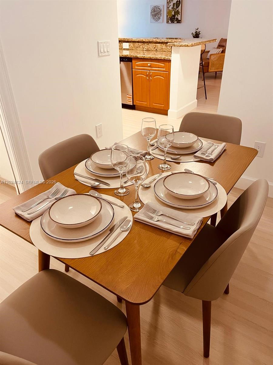120 South Douglas Road, Unit 302 Miami, FL 33134 - Photo 10 of 28 a dining room with furniture and wooden floor