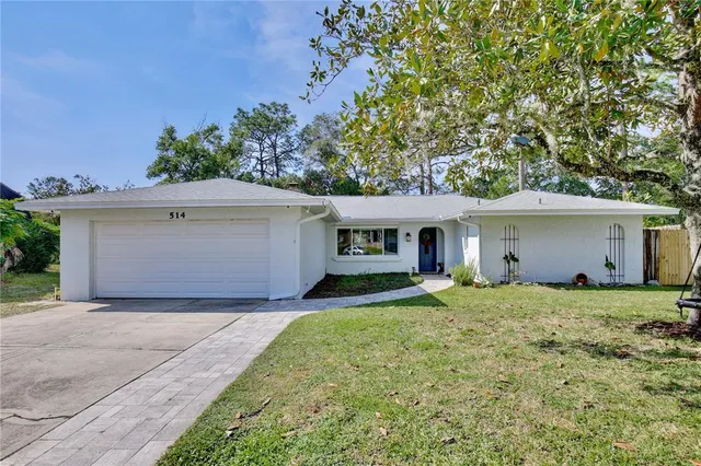a front view of house with yard and trees